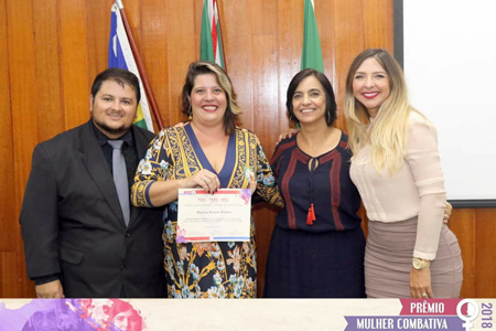 Professora Mariana recebendo a homenagem, segunda da esquerda para a direita